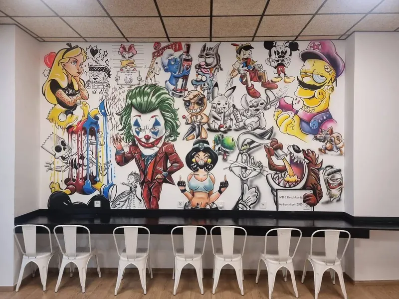 Zona común del alojamiento con mural y mesa alta con taburetes