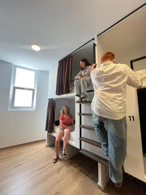 Litera con cortina y ventana en una habitación para grupos