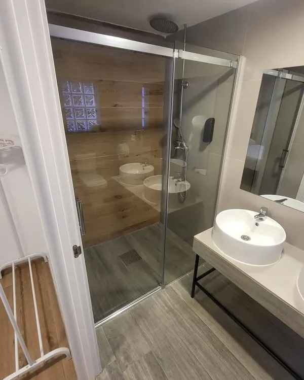 Baño con ducha y lavabo en el alojamiento para grupos